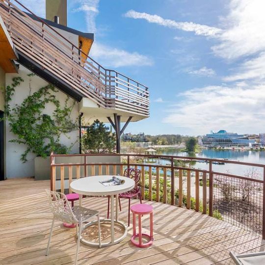 Image of a wooden deck with a table and chairs overlooking the lake at villages nature