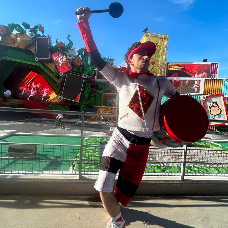 Image is of a performer with a drum dressed in red and white