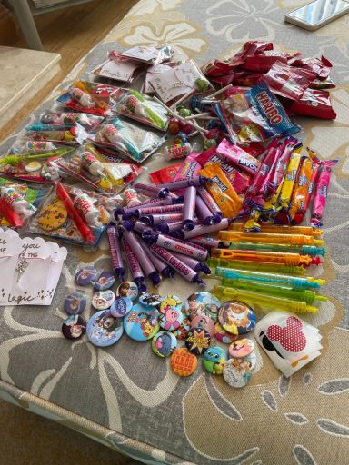 Image shows a pile of sweets, stickers, badges, bubbles and cellophane packets