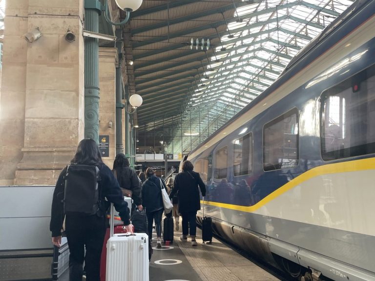 Image shows a eurostar train at a platform with passengers walking down the platform