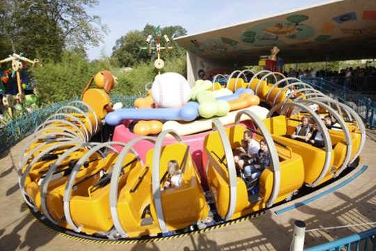 Image shows the slinky dog ride which inludes seats amongst the slinks of slinky dog, in a circular shape around a bowl containing bones and a baseball