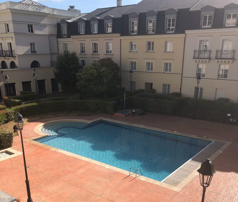 Image shows an outdoor rectangular pool within a courtyard