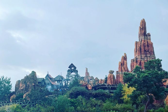 Image of a rocky outcrop with trees in the foreground, reminiscent of the wild west landscape