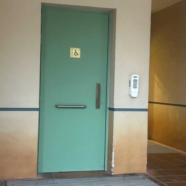 Image of a wooden door with a wheelchair symbol