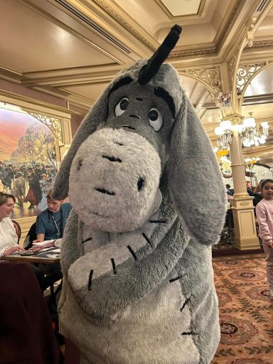 Eeyore the grey donkey standing near to a table