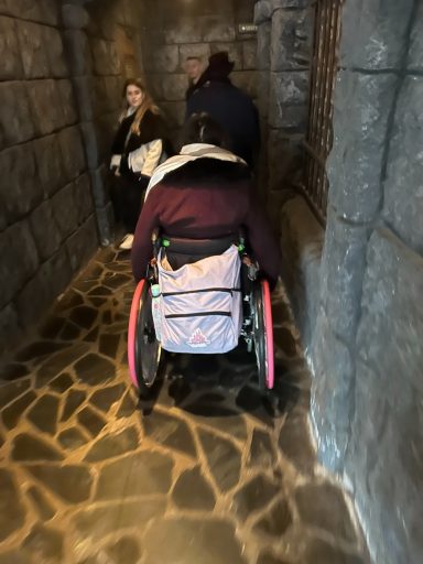 Stone walls and stone flooring with the back of a wheelchair user