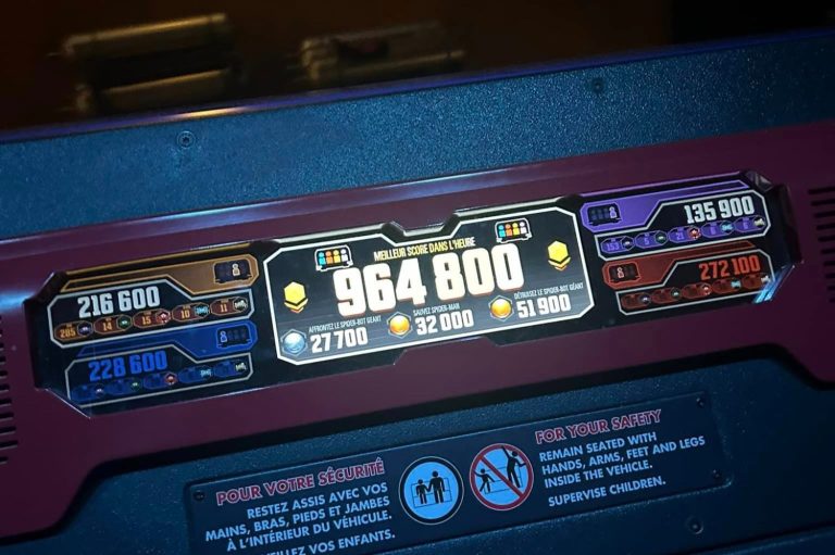 Image of the scoreboard within the ride vehicle showing the whole vehicles combined score in the centre and individual scores at each side