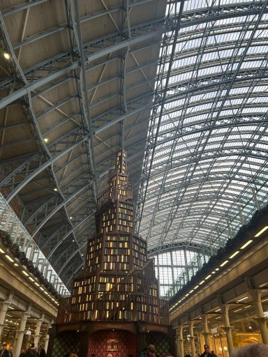 A structure similar in shape to a large chrostmas tree but made up of what appears to be books