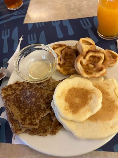 a plate on a table with mickey shaped mini waffles, pancakes and crepes on it