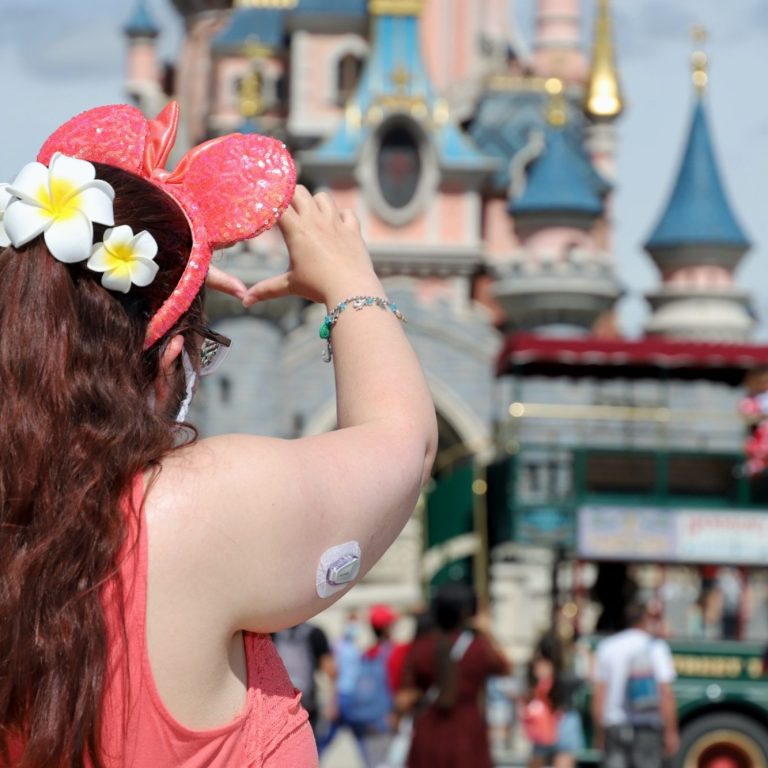 Image of Jody facing the castle with her back to the camera, her Dexcom sensor is visible on her arm