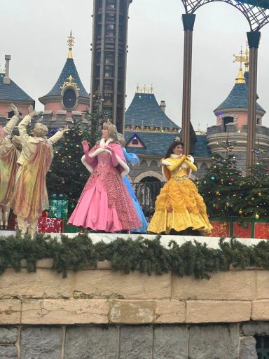 Aurora and Belle are on a stage with some dancers dressed in gold