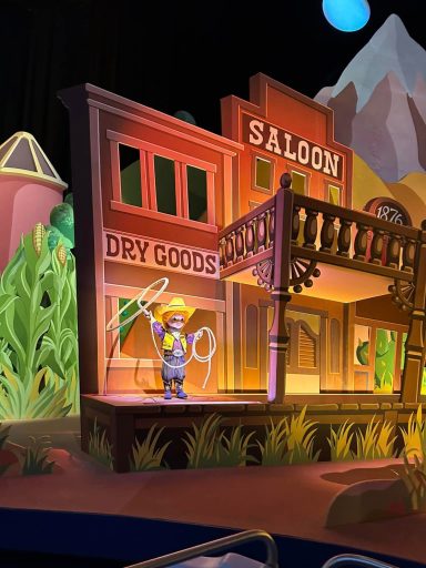 A scene from it's a small world with a wild west scene and a cowboy doll