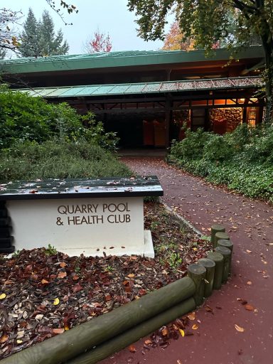 Image of a woodland path with a sign for the quarry pool and health club