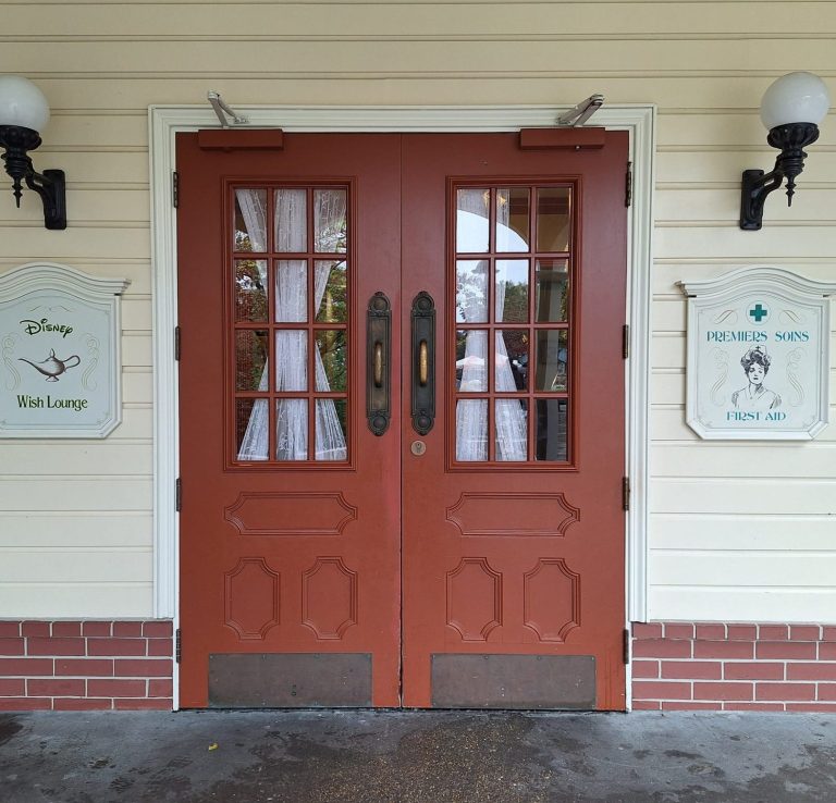 Image of a pair of brown double doors with signs showing this is the first aid centre