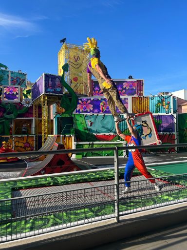 two acrobats are on a trampoline with one holding the other up in the air