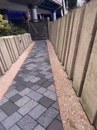 A path with grey stone tiled floor and sandstone coloured walls at either side