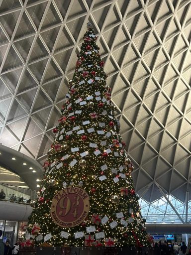 Large christmas tree with a platform 9 3/4 plaque and multiple letter and ornaments themed to Harry Potter