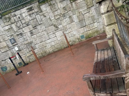 Red stone floor, a stone wall and a wooden bench