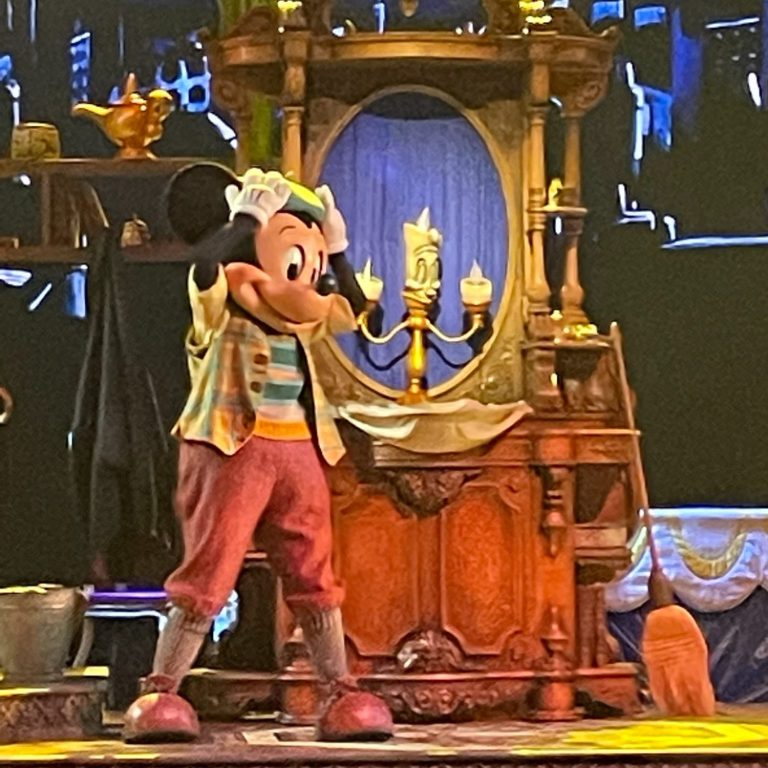 An image of Mickey in the show mickey and the magician, he is standing with lumiere