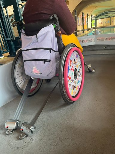 A wheelchair secured in place with straps to the underside of the chair