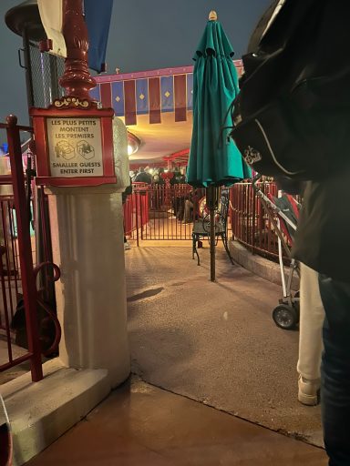 Image of a waiting area with a green parasol and a metal bench