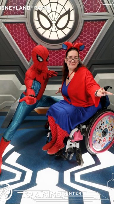 A picture of a character meet with spiderman and a woman in a wheelchair dressed in a spiderman inspired look