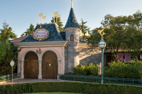 Exterior of the princess pavilion with pink walls, blue slate roof, a turret and large wooden doors so it is themed like a castle