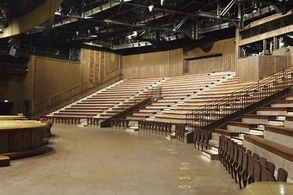 Image shows an empty theatre with a wide open floor then tiered bench seating 