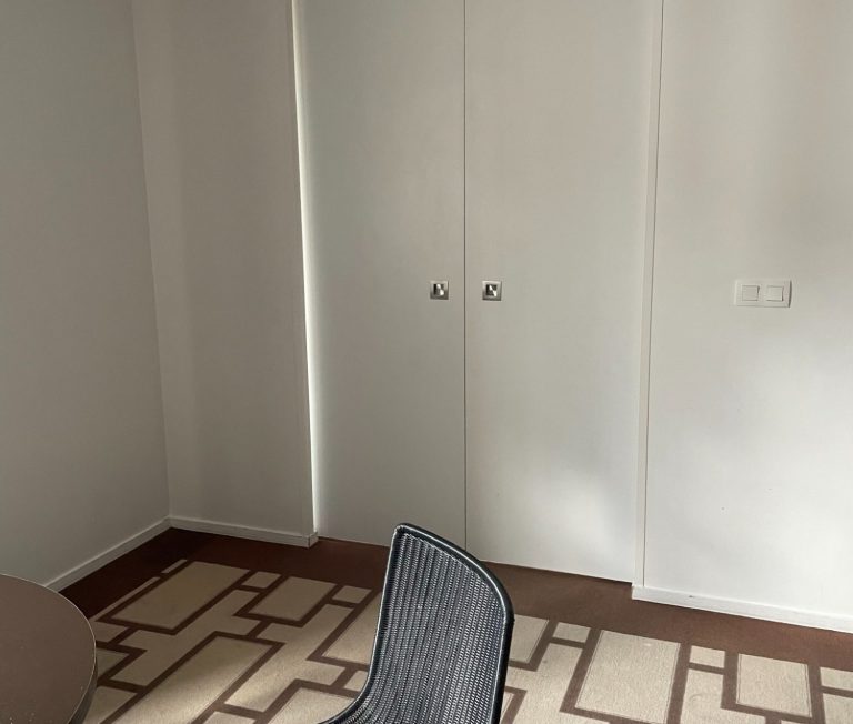 Image of a pair of sliding doors which are closed and the carpeted floor of the room