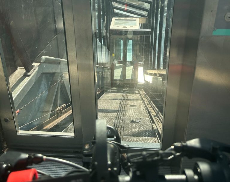 Image shows glass doors and an incline lift shaft