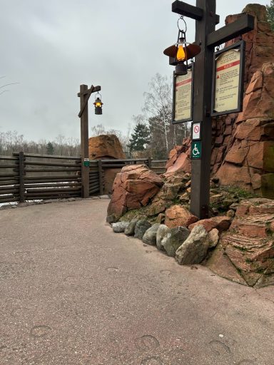 red concrete path with red stone features and wooden fences, and some frontier style lights