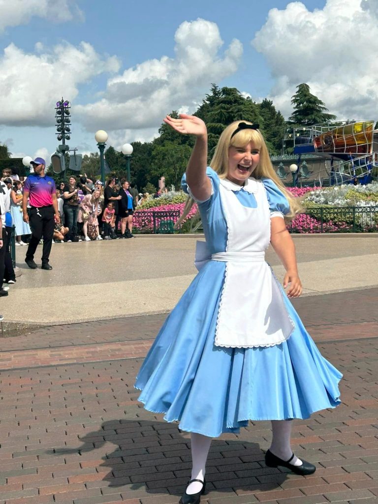 Alice in wonderland appearing in Central Plaza, waving and smiling