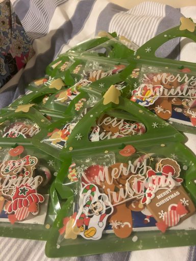 Image of christmas tree shaped bags containing candy canes, chocolate and stickers