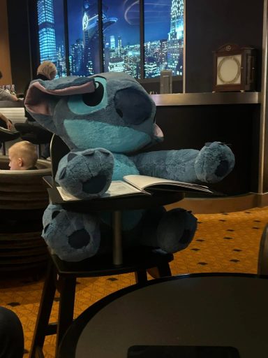 A large stitch plush is seated in a highchair