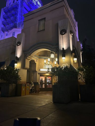 image of a corner of a building with a porch in the dark, there is a doorway