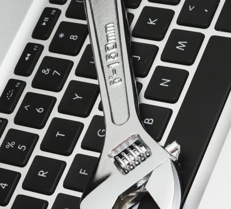 Image of a spanner on top of a computer keyboard