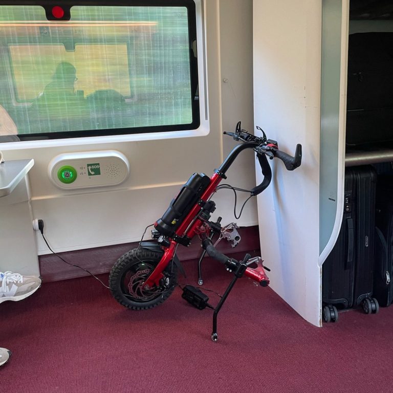 Image of the rio firefly 2,5 electric handcycle attachment standing on a train