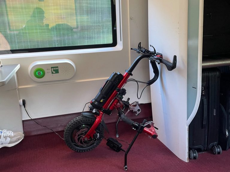 wheelchair space on eurostar with an electric handcycle attachment parked in it