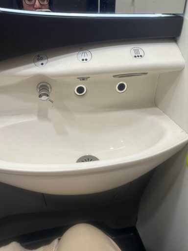 image showing a sink in the bathroom and knees can be seen slose to the undersink area