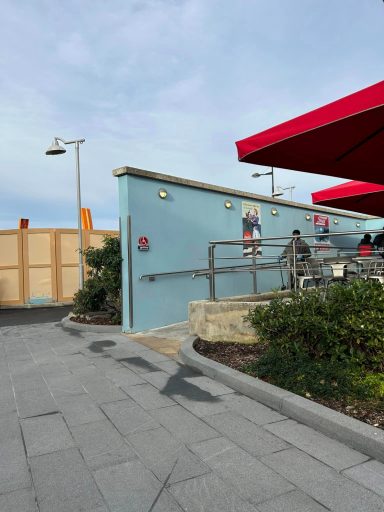 A blue wall and a ramp with a silver handrail