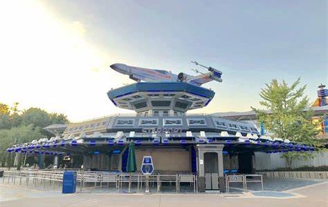 Exterior of the Starport attraction, a blue and white building with a star wars plane on top