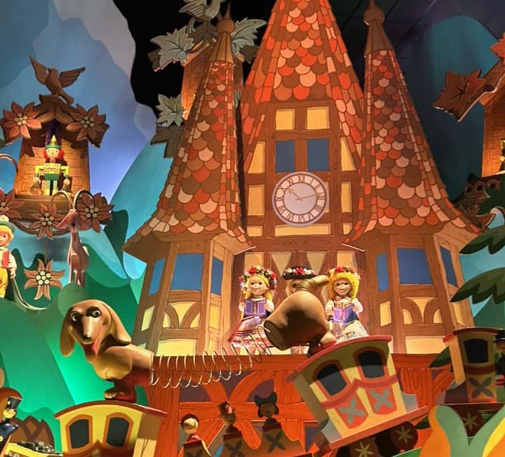 Image of the interior of It's a small world showing a swiss style cottage and doll sin traditional swiss outfits