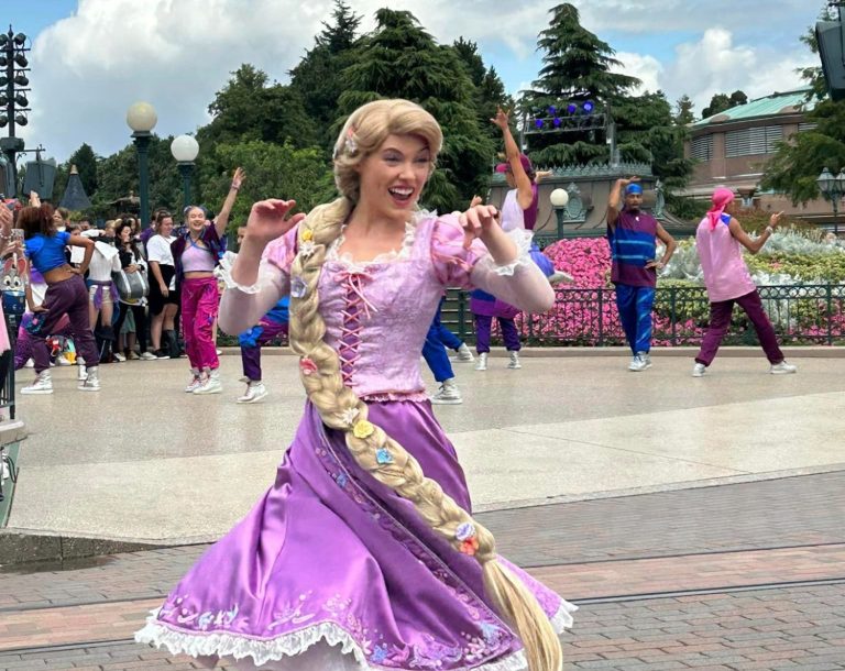 The image shows Rapunzel twirling around as part of a parade 