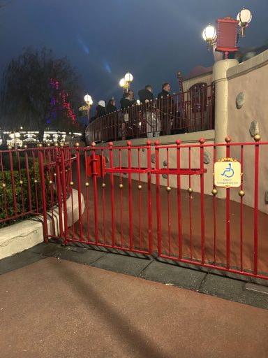 Image of a red metal gate with a wheelchair symbol on it