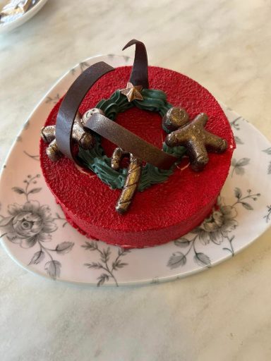 A round red cake decorated with chocolate swirls and chocolate gingerbread men