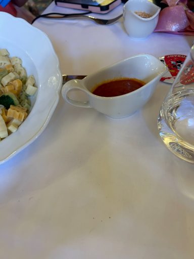 A white jug containing tomato pasta sauce