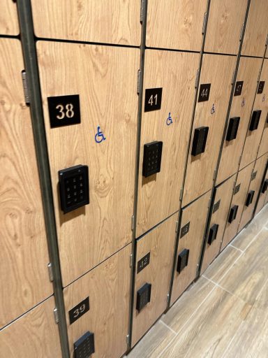 A row of wooden lockers with electronic keypads, the middle row have wheelchair symbols on them