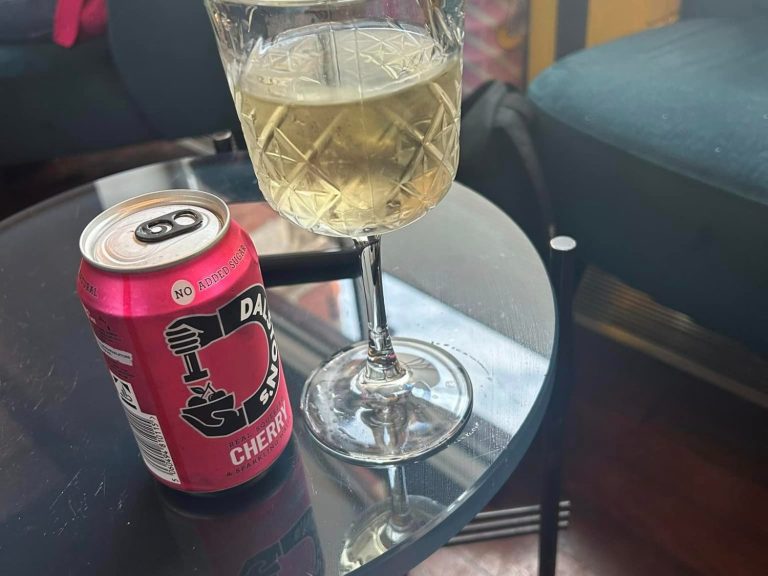 Image showing a glass of wine and a can of cherry soda in the business lounge