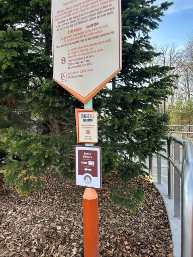 A sign explaining that green priority pass holders use the main ride entrance