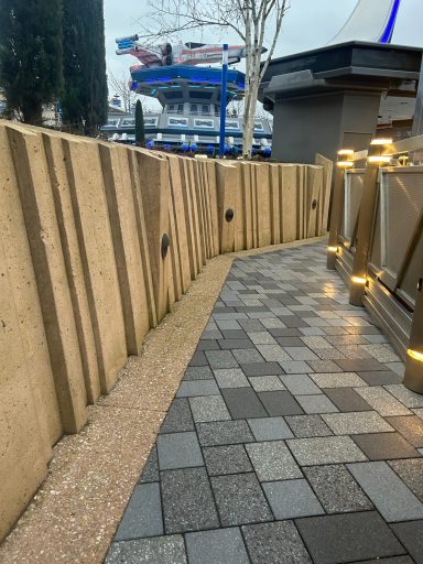 A path with grey stone tiled floor and sandstone coloured walls at either side